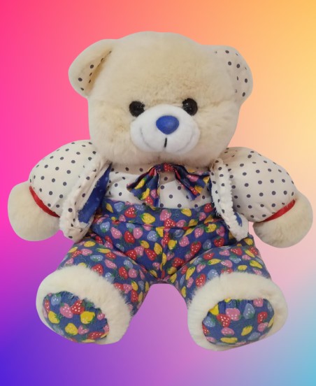 Peluche de oso de color beige con traje de colores y corbatín.